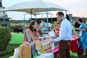 woman speaking with a man outside by vendor table